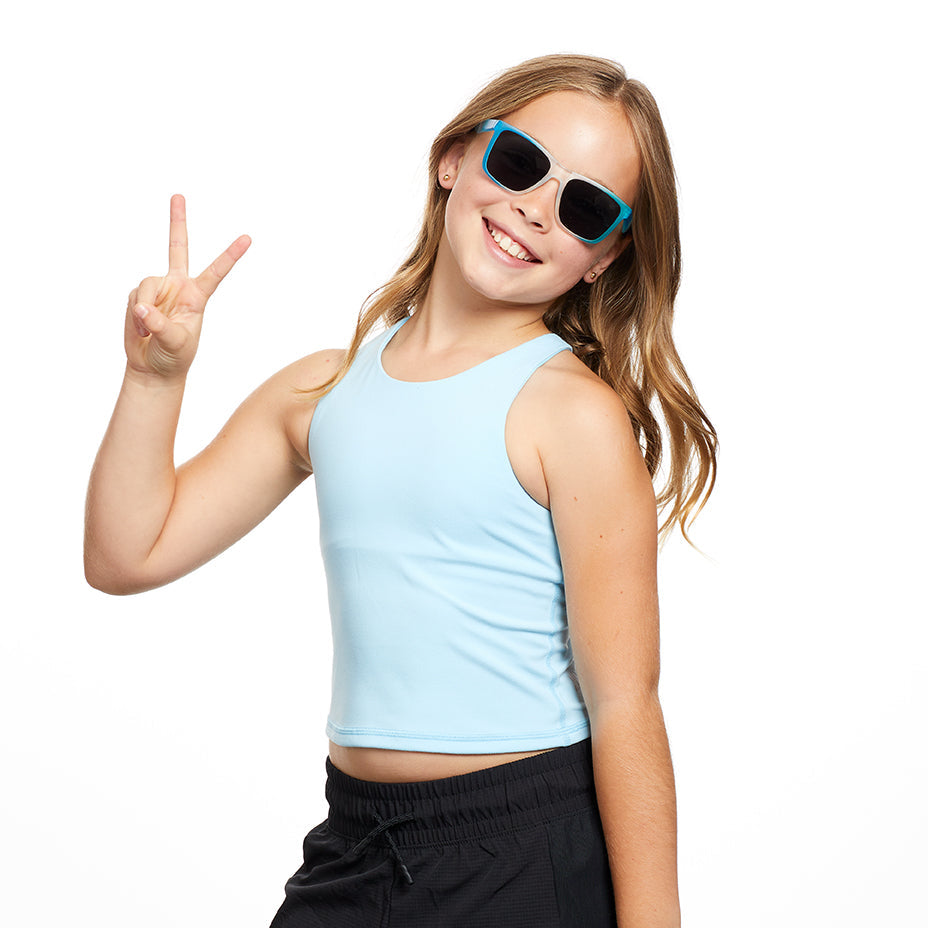 Young kid wearing floating sunglasses, making a peace sign on a white background